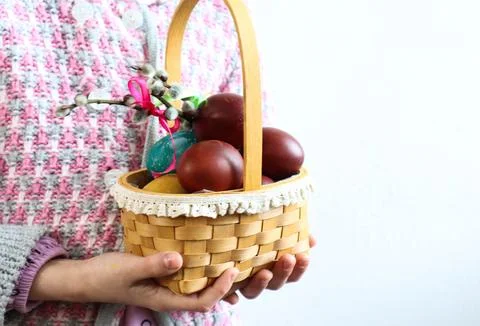 Easter basket in children's hands on a light background, space for text Stock Photos