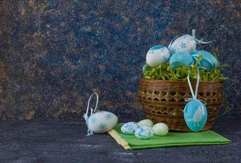 Easter basket with coloured Easter eggs on dark stone table 写真素材