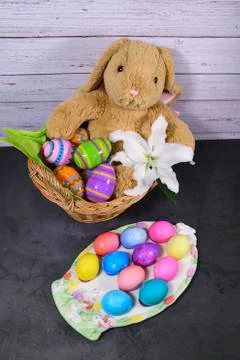 Easter Basket with Easter Bunny and Easter Eggs on decorative plate Stock Photos