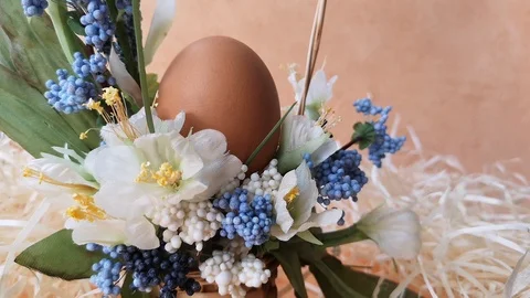 Easter basket with egg and flowers among straw Stock Footage 104589591