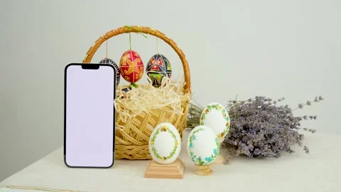Easter basket with eggs and a green screen phone on a white background. Chroma Stock Footage 301743497