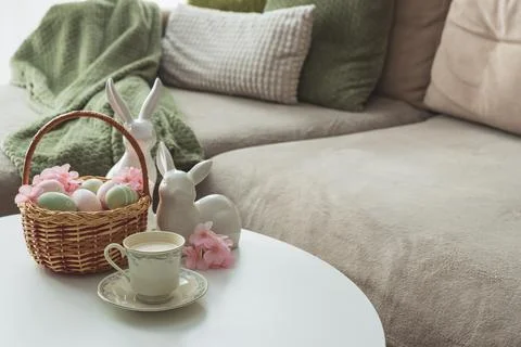 Easter Basket with Ester Eggs, Bunny Figurines and coffee cup on White Tabl.. Stock Photos