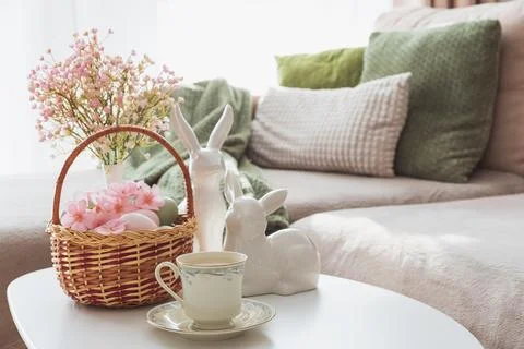 Easter Basket with Ester Eggs, Bunny Figurines and coffee cup on White Tabl.. Stock Photos