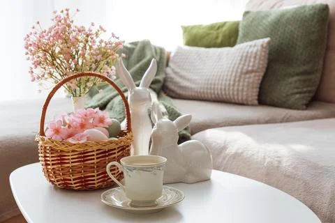 Easter Basket with Ester Eggs, Bunny Figurines and coffee cup on White Tabl.. Stock Photos