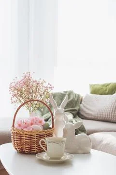 Easter Basket with Ester Eggs, Bunny Figurines and coffee cup on White Tabl.. Stock Photos