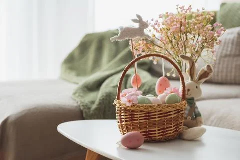 Easter Basket with Ester Eggs,  Plush Bunny and Spring Decor on White Table.. Stock Photos