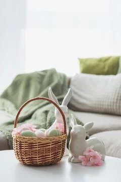 Easter Basket with Ester Eggs,  Plush Bunny and Spring Decor on White Table.. Stock Photos