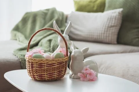 Easter Basket with Ester Eggs,  Plush Bunny and Spring Decor on White Table.. Stock Photos