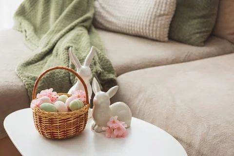 Easter Basket with Ester Eggs,  Plush Bunny and Spring Decor on White Table.. Stock Photos