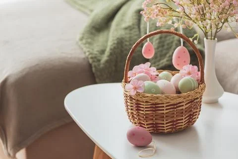 Easter Basket with Ester Eggs,  Plush Bunny and Spring Decor on White Table.. Stock Photos
