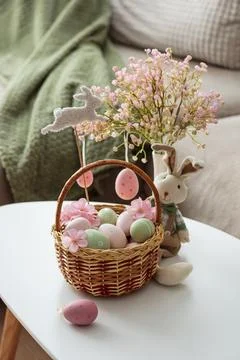Easter Basket with Ester Eggs,  Plush Bunny and Spring Decor on White Table.. Stock Photos