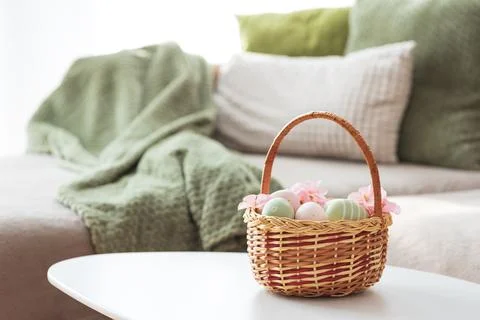 Easter Basket with Ester Eggs,  Plush Bunny and Spring Decor on White Table.. Stock Photos