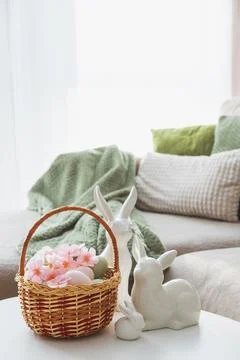 Easter Basket with Ester Eggs,  Plush Bunny and Spring Decor on White Table.. Stock Photos