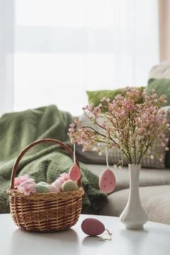 Easter Basket with Ester Eggs,  Plush Bunny and Spring Decor on White Table.. Foto stock