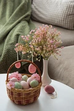 Easter Basket with Ester Eggs,  Plush Bunny and Spring Decor on White Table.. Stock Photos