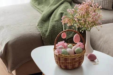 Easter Basket with Ester Eggs,  Plush Bunny and Spring Decor on White Table.. Stock Photos