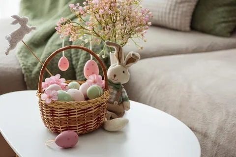 Easter Basket with Ester Eggs,  Plush Bunny and Spring Decor on White Table.. Stock Photos