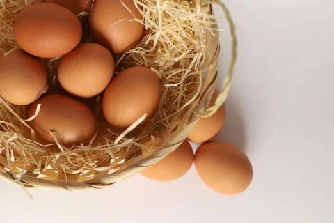 Easter basket on its side. Brown eggs in a basket on a straw, next to the bas Stock Photos