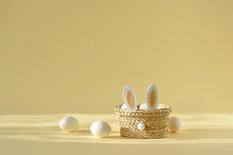 Easter basket with rabbit ears and eggs on a yellow background. Easter. Festi Stock Photos