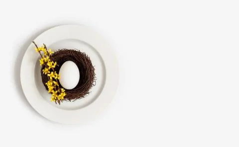 Easter beautiful table setting with a chicken egg in a nest  Stock Photos