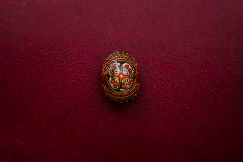 Easter black egg  with a handmade pattern. Closeup view on empty magenta leat Stock Photos