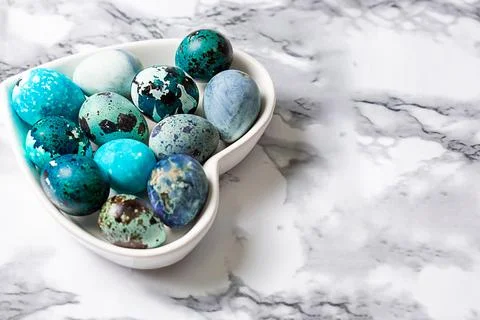Easter blue quail eggs in a plate in the shape of a heart on a wooden table Stock Photos