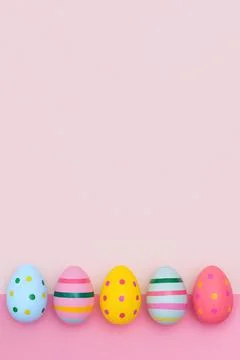 Easter border of vivid Easter eggs on a pink background. Fotos de archivo