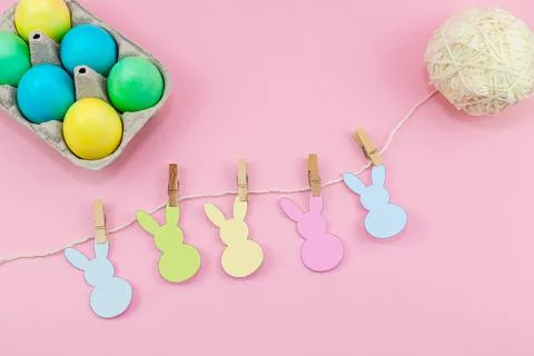 Easter. Box of colorful eggsand easter decoration of the room on a pink backg Stock Photos