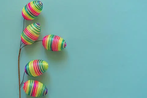 Easter branch of multicolored rainbow eggs on blue background Stock Photos