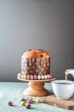 Easter bread, panettone with chocolate eggs on the wooden stand and a cup of Stock Photos