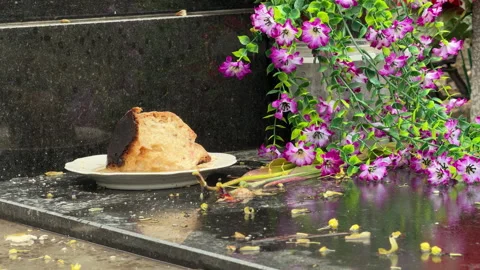Easter Bread Slice And Bright Artificial Flowers Rest On A Polished Grave Tomb Stock Footage 334036814