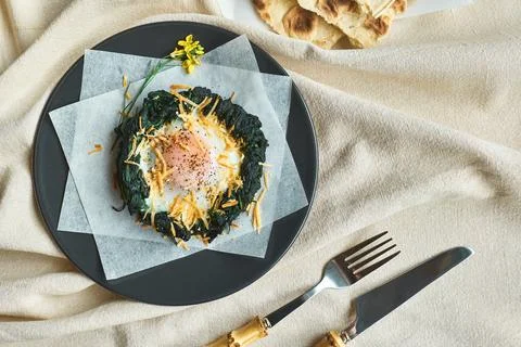 Easter breakfast idea. Baked spinach egg nests decorated with grated cheese.. Stock Photos
