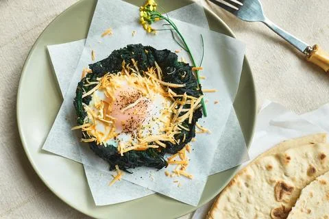 Easter breakfast idea. Baked spinach egg nests decorated with grated cheese.. Stock Photos