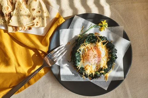 Easter breakfast idea. Baked spinach egg nests decorated with grated cheese.. Stock Photos