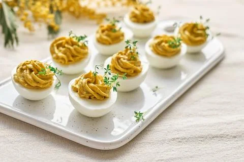 Easter breakfast idea. Stuffed easter eggs mimosa with egg yolk, turmeric, .. Stock Photos