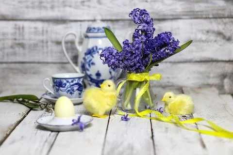Easter breakfast table with tea,eggs in egg cups, spring flowers in vase and Stock Photos