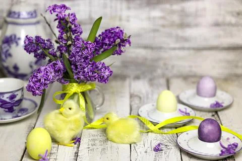 Easter breakfast table with tea,eggs in egg cups, spring flowers in vase and Stock Photos