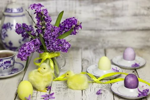 Easter breakfast table with tea,eggs in egg cups, spring flowers in vase and Stock Photos