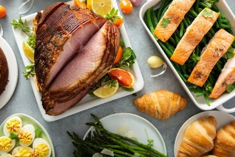 Easter brunch with spiral cut ham and roasted salmon Stock Photos