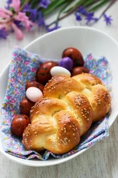 Easter bun, colored eggs and flowers on a white background. Stock Photos