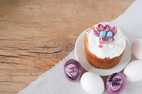An Easter bun with colorful eggs is on the table. Stock Photos