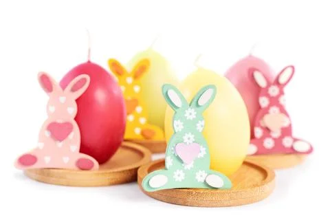 Easter Bunnies next to egg shaped candles Stock Photos