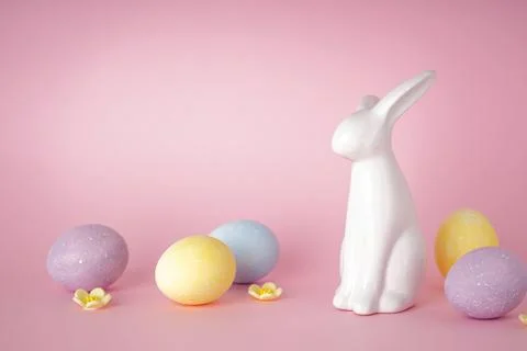 Easter bunny and colored easter eggs on pink background. Place for text. Happ Stock Photos