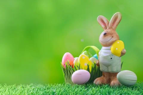 Easter bunny and decorative Easter eggs on a green meadow. Photos