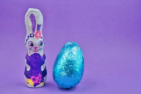 Easter Bunny and Easter Blue Egg And Cross on Purple Background Stock Photos