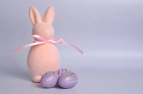 Easter bunny and Easter eggs painted in purple. Celebration of Easter. Stock Photos