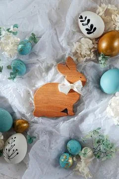 Easter Bunny and Easter eggs with candy and flowers on white paper. Happy E.. Stock Photos