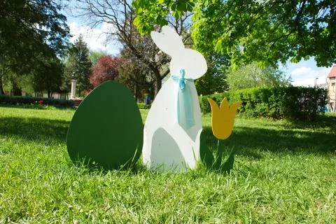 Easter Bunny and Egg Decorations on Green Grass in Sunny Spring Park Stock Photos