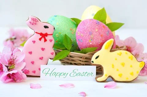 Easter Bunny and eggs. Easter eggs and flowers with bunny statuettes on wooden Stock Photos