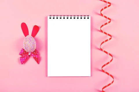Easter bunny and notepad on pink background. Foto stock